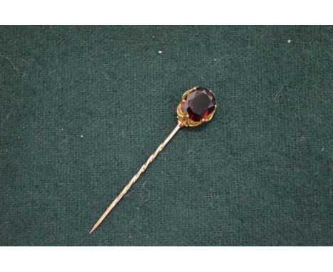 A gold and gem set tie pin.