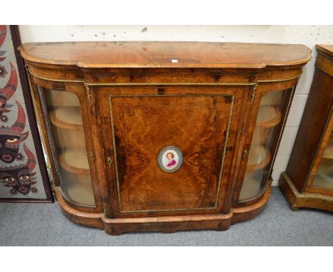 A good Victorian figured walnut credenza, the central panelled door inset with a porcelain portrait plaque, flanked by a pair