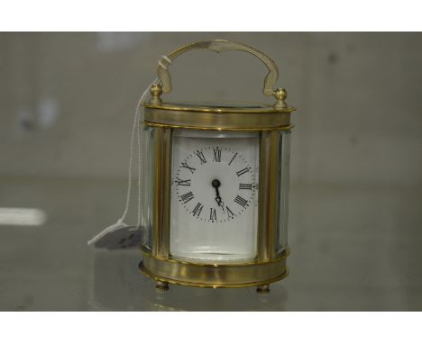 A small oval shaped carriage clock with plated case.