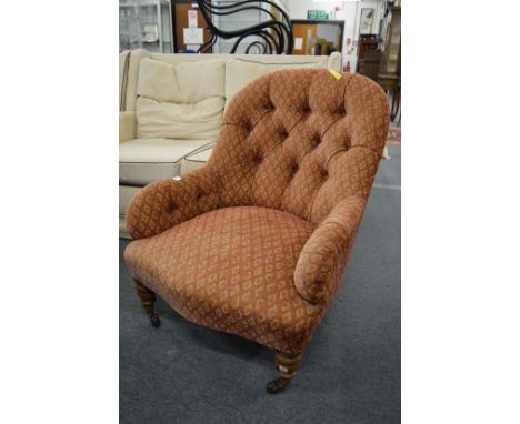 A Victorian button upholstered nursing chair on turned supports with brass castors stamped Cope and Collinson.