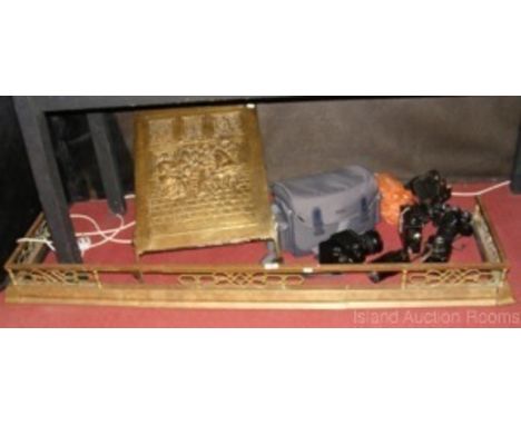 An adjustable brass fire fender and an embossed brass fireguard