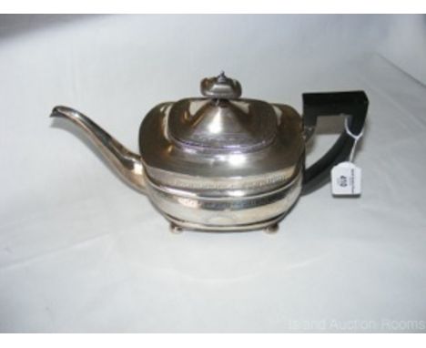 A silver teapot with engraved decoration