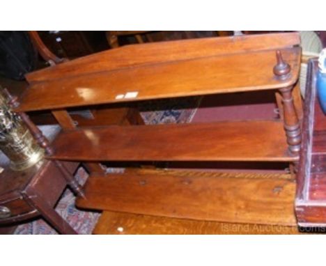 A triple mahogany hanging wall shelf with turned supports