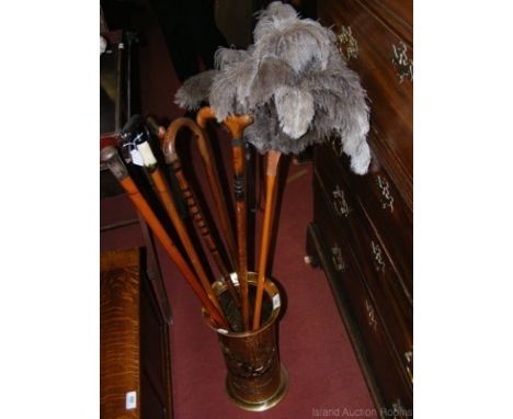 An embossed brass umbrella/stick stand, five various walking canes, etc.