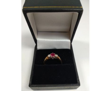 A 9ct gold three-stone diamond and ruby ring with box. 