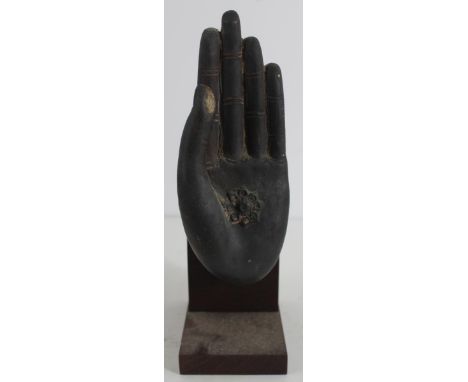 Thai Patinated Metal Hand Fingers poised in the Mudra Abhaya position, the palm with a stylized amulet, affixed to a wood bas