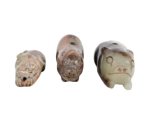 Three Chinese Jade and Hardstone Pigs The first, a brown and reddish-purple mottled stone example, the second, a calcified ja