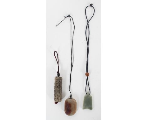 One cylinder with a textured design, one brown and tan carving, and one green jade piece. All with a tassel attached. Size: 1