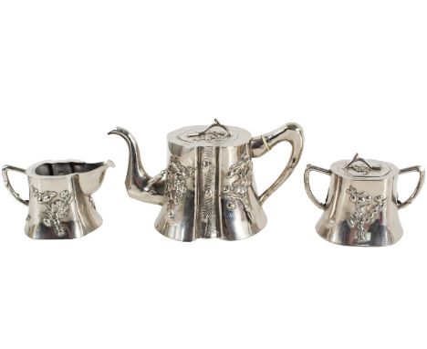 Early 20th Century. Unmarked. The teapot, covered sugar and creamer, cast to depict a stylized tree trunk, each chased with b