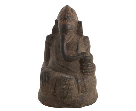 Indian Carved Granite Figure of Ganesh. South India, Chola Dynasty, 11th Century. The deity seated on his throne, bejeweled a