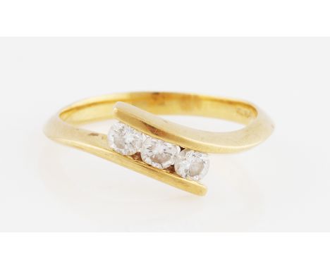 An 18ct yellow gold three stone diamond ring, bar set with three round brilliant cut diamonds in cross over design, total dia