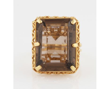 A smoky quartz dress ring, set with a rectangular cut smoky quartz, with open metalwork gallery, indistinctly stamped, ring s