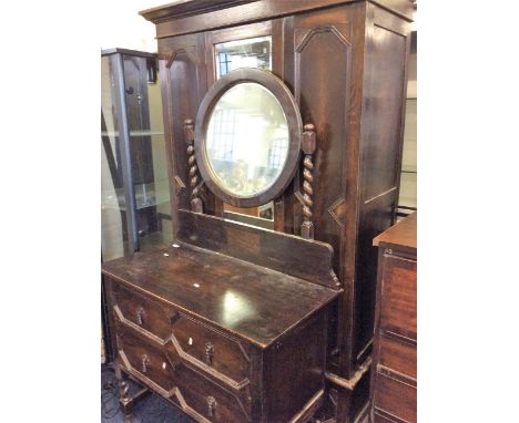 An oak two piece bedroom suite comprising of a mirror single door wardrobe and one dressing table.