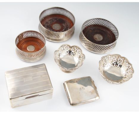 A collection of hallmarked silverware, to include three wine coasters, two pierced dishes, a cigarette box and a cigarette ca