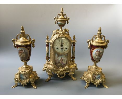 A French style brass and ceramic clock with two garnishes, decorated with pastoral couple scenes.