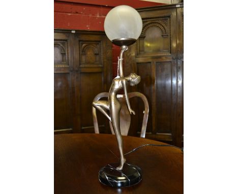 A contemporary table lamp as an Art Deco gymnast holding aloft a ball.