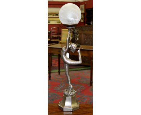 A contemporary table lamp as an Art Deco Snake girl holding a ball, cobras at her feet.