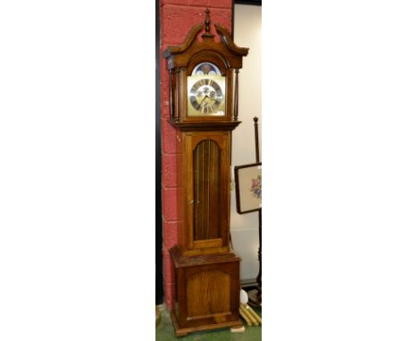 A late 20th century oak longcase clock with Westminster chime, weights and pendulum 