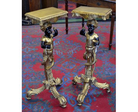 A modern pair of giltwood Blackamoor tripod torcheres.