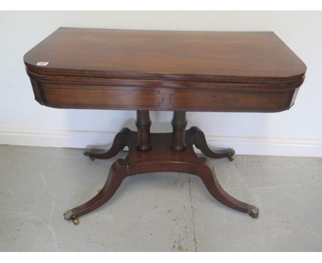 A 19th century fold over card table on twin pillar supports and quatrefoil base, 72cm tall x 92cm wide good colour and patina