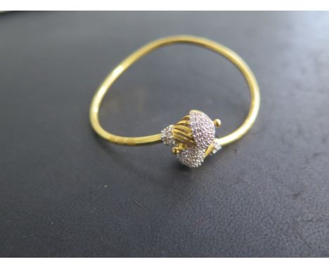 A sprung yellow metal bangle marked KD916 FJR, 6cm wide, approx 11 grams, in good condition 