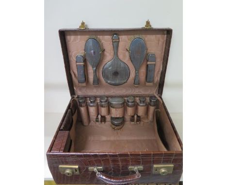 A very good quality early 20th century crocodile travelling case with silver fittings, having silver hair and clothes brushes