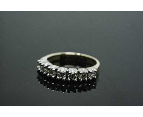 An 18ct white gold seven stone diamond half eternity ring, approximately 0.7ct, size P.