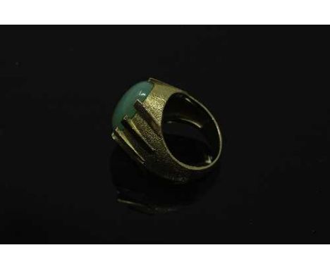 A continental yellow gold ring, the textured shank set with a cabochon apple green jade stone, size N, 10.8g.