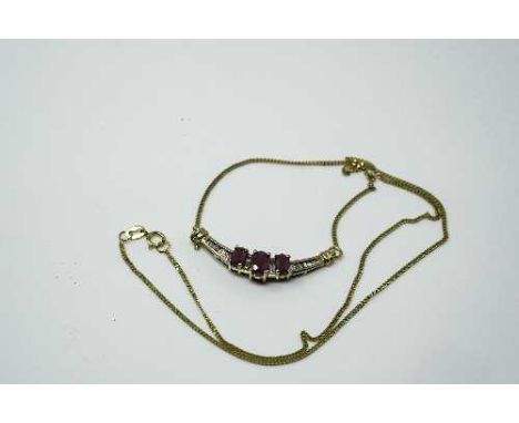 An 18ct yellow gold ruby and diamond pendant on chain, set with fourteen baguette cut diamonds approximately 0.16ct, the cent