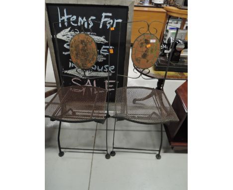 A pair of folding metal garden chairs