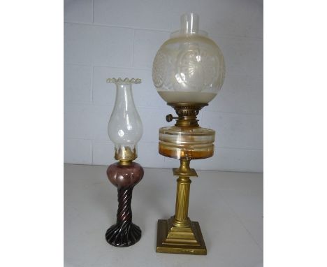 Antique brass based oil lamp with clear glass well and one other in an unusual Amethyst colour. 