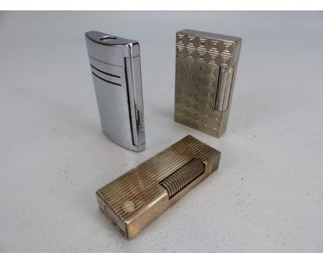 Two silver coloured DUPONT lighters and a dunhill lighter