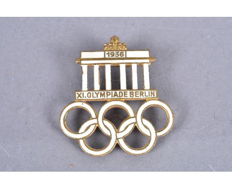 A 1936 Berlin Olympic gilt and white enamel badge, stamped with maker's name 'Deschler Munchen, Ges-Gesch' 
