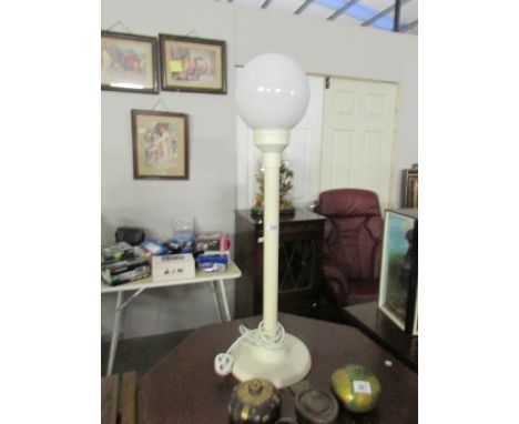 A tall modern table lamp with globe shade