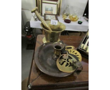 A brass pestle and mortar, a brass chamber candlestick and 2 horse brasses