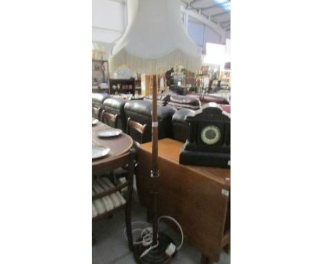 A wooden standard lamp with shade