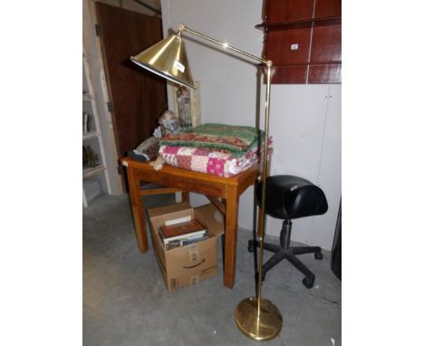 A brass floor standing adjustable reading lamp
