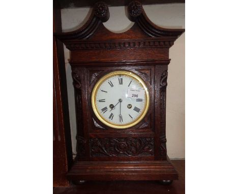 Victorian carved oak mantle clock with swan neck pediment having French movement, striking on a gong, 15" high