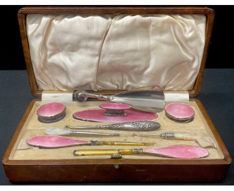 An Edwardian silver and enamel manicure set, set with pink engine turned enamel, part fitted, Birmingham 1902, Morocco leathe