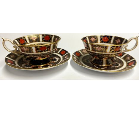 A matched pair of Royal Crown Derby Imari 1128 pattern pedestal teacups and saucers, printed marks, one first quality, the ot