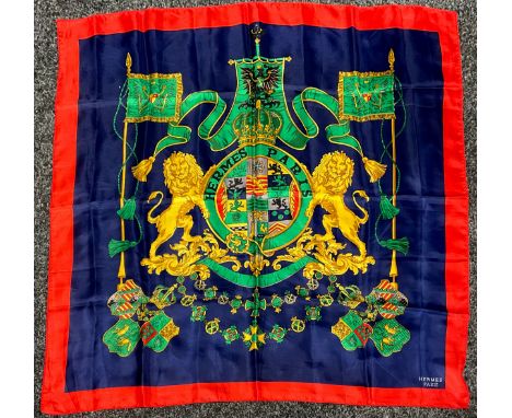 A Hermes Paris silk scarf, decorated with Hermes lion crest on blue ground, broad red border, 85cm x 85cm