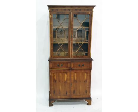 Two 20th century yew bookcase cabinets with astragal-glazed doors above two drawers to two cupboard doors, on bracket feet