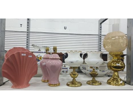 A pair of paraffin lamp style table lamps, a paraffin lamp converted to electricty, a pair of pink and gilt ceramic table lam