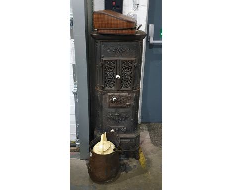 Old decorative cast iron stove, a pair of pierced fretwork panel doors enclosing cooking compartment with fire below and ash 