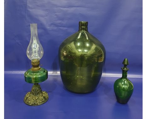 Green glass carboy, a green glass decanter and an oil lamp with metal base and green glass reservoir (3) 