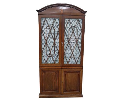 19th century mahogany arched top bookcase with diamond inlay to arch, above the two astragal-glazed fabric-backed doors, encl