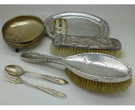 Two silver backed brushes, a silver napkin ring, an 800 silver fork and spoon and two plated dishes