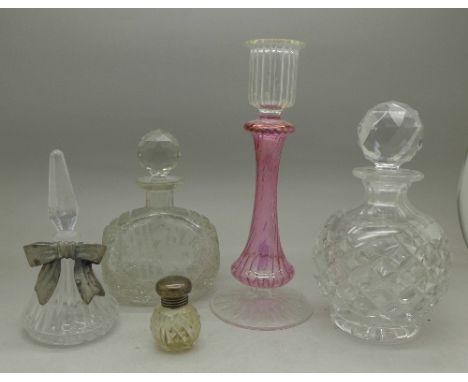 Four scent bottles including one with silver top and a glass candlestick
