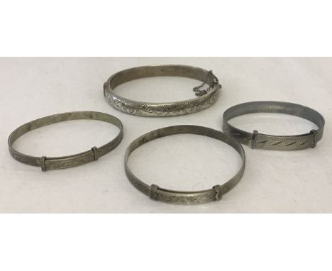 A vintage silver bangle with half floral engraving and safety chain.  Together with 3 children's silver extending christening