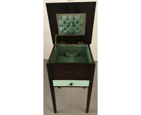 A vintage dark wood work box with green painted detail.  Interior is lined with green fabric, pin cushion to lid, sectional d
